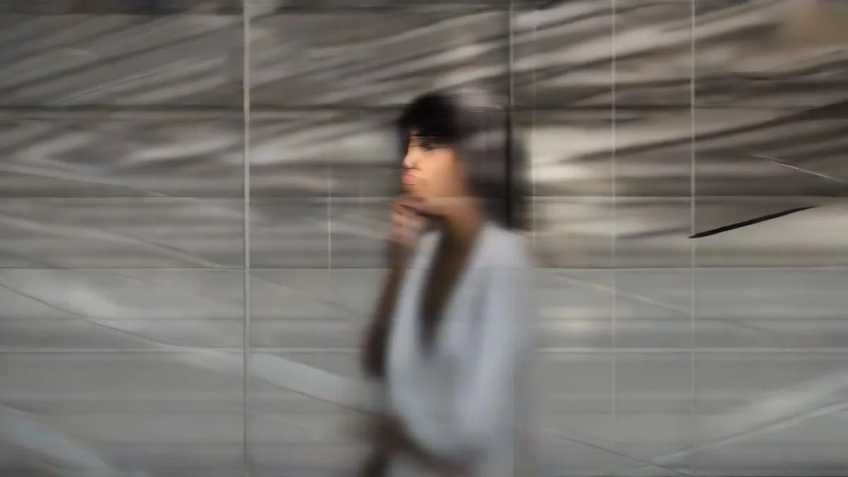 A thoughtful woman looking out an office window contemplating her career resignation